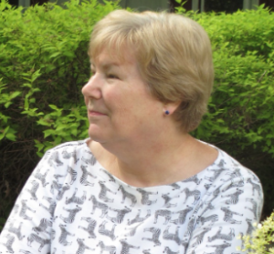 A woman in front of a bush.