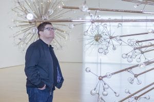 Josiah standing among his glass sculptures