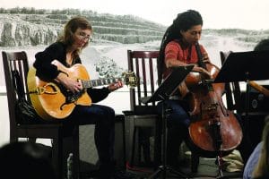 Mary seated playing the cello inside the gallery.