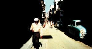 A man walking down a sunlit street