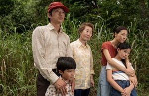 A family embraces each other in lush field