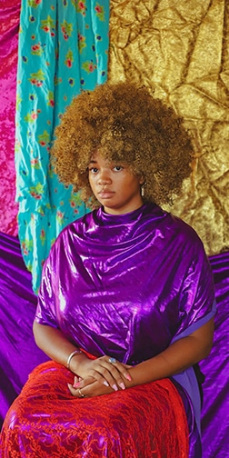 A woman posing for the camera wearing colorful clothing.