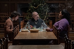 A group of people sitting around a table at Christmas.