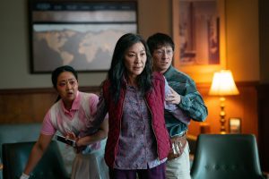 three people in a violent scene, looking beyond the camera dramatically.