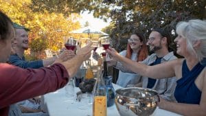 a group of people at a dinner table holding up wine glasses