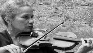 A woman holding up a violin.