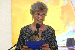 A woman speaking at a microphone.