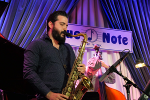 A man on stage playing saxophone.