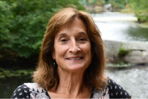 A headshot of a woman in front of a river.