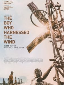 A young boy standing on top of a windmill.