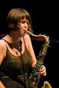 A woman playing a tenor saxophone.