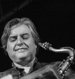 A black and white image of a man playing a saxophone.