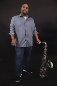 A man holding up a saxophone