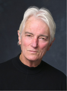 A headshot of a man with gray hair staring at the camera.