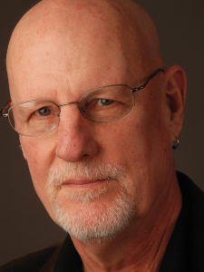 A headshot of a man with glasses and a beard.