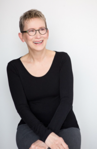 A headshot of a woman with glasses.