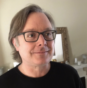 A headshot of a man wearing glasses.