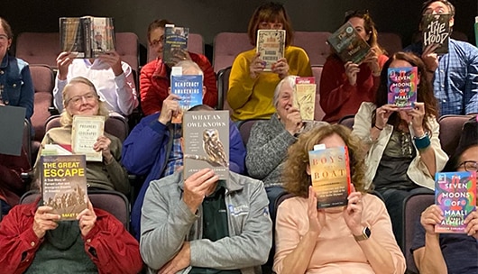 A group of people holding up books.