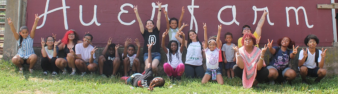 A group of kids holding up peace signs towards the camera.